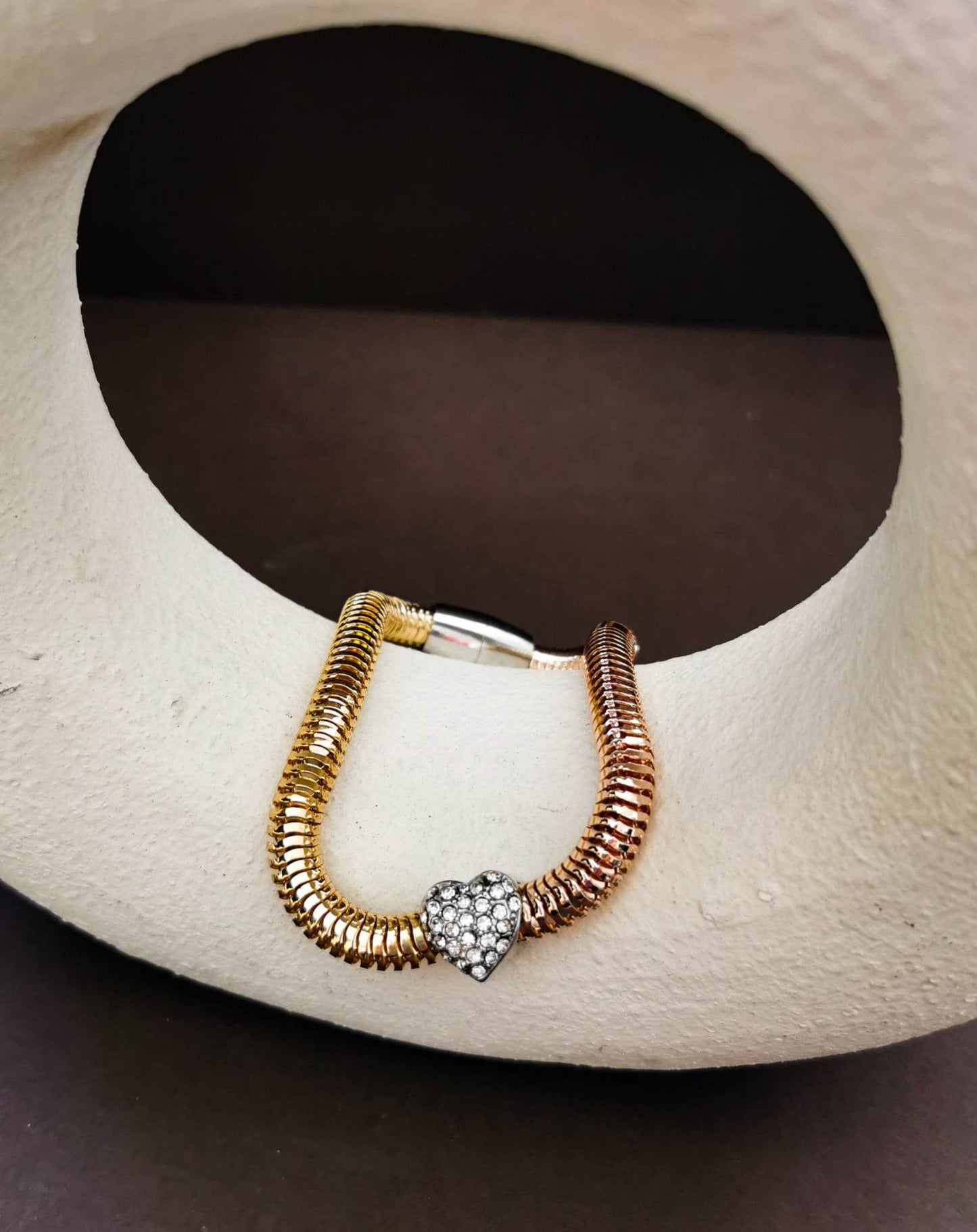 Gold tone bracelet with crystal heart detail